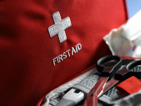 Red first aid kit bag with scissors and bandages
